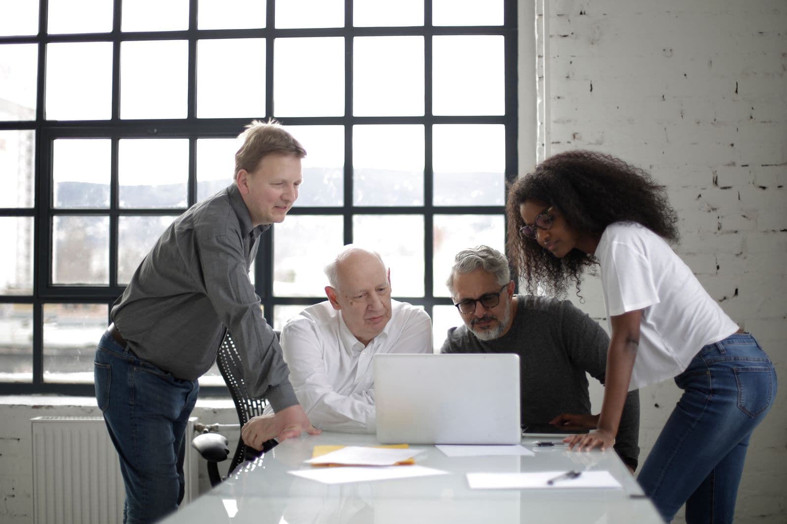 Des collaborateurs réunis autour de leur espace de travail.